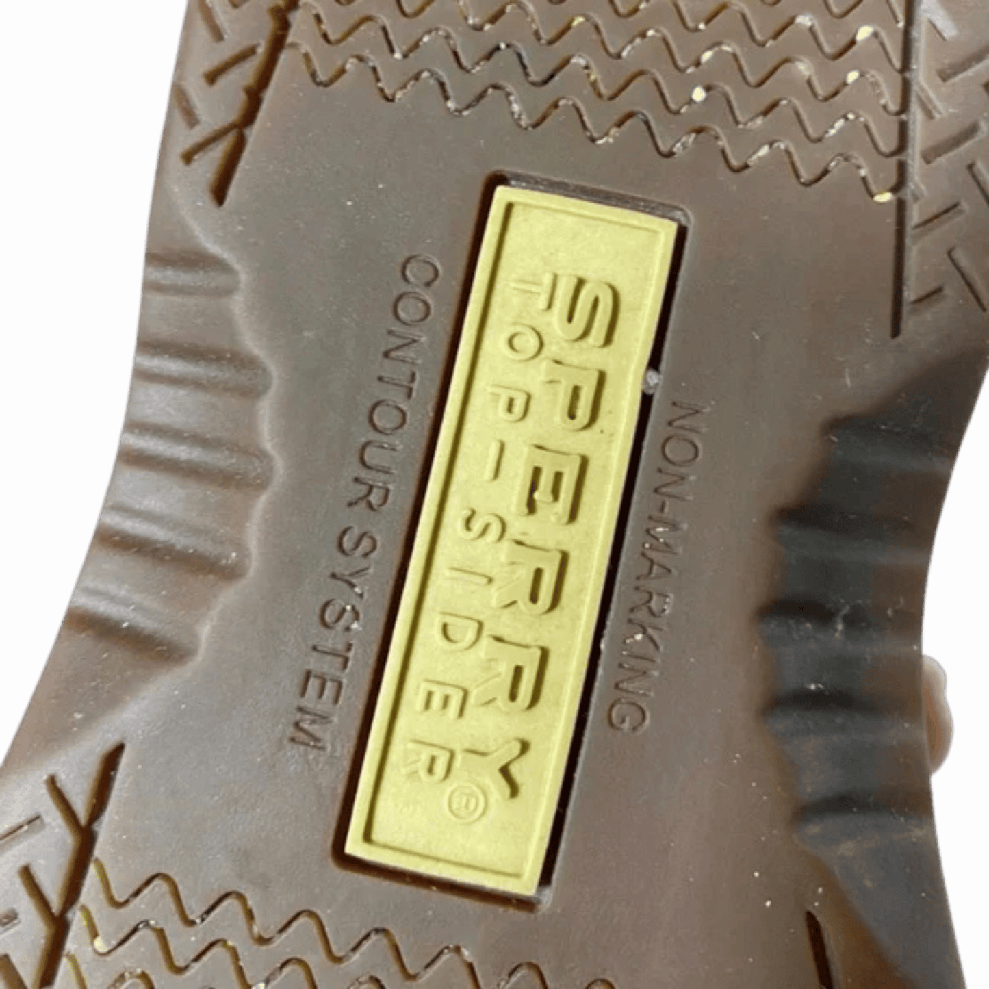 Close-up of a Sperry logo on the sole of a shoe with a gray background