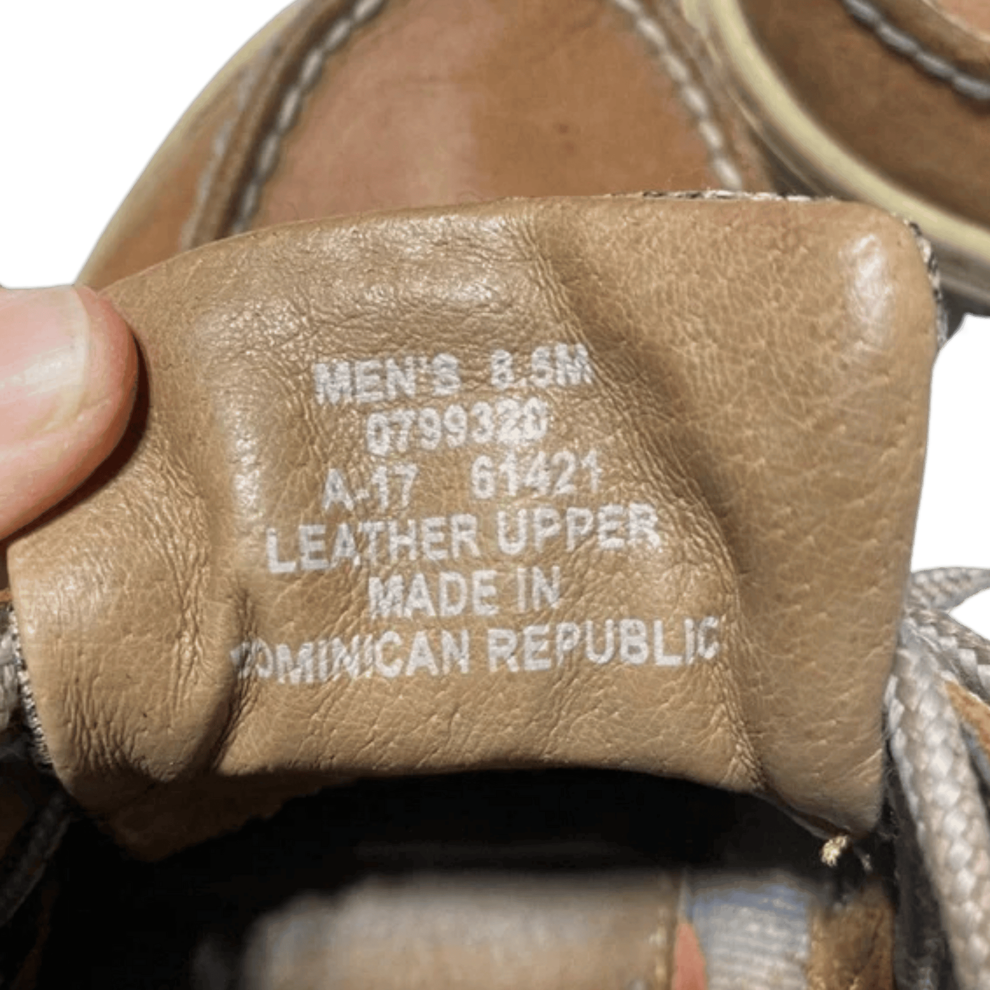 Close-up of a sandal's leather upper label with text on a green background