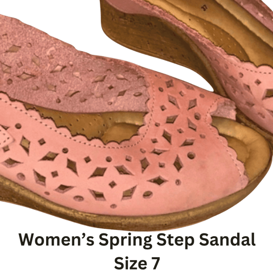 Pink women's sandal with cut-out design on a green background