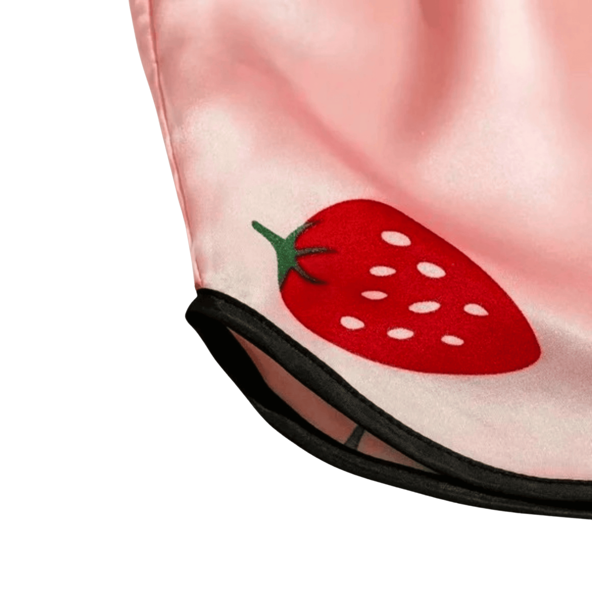 Close-up of a pink fabric with a red strawberry design on a green background