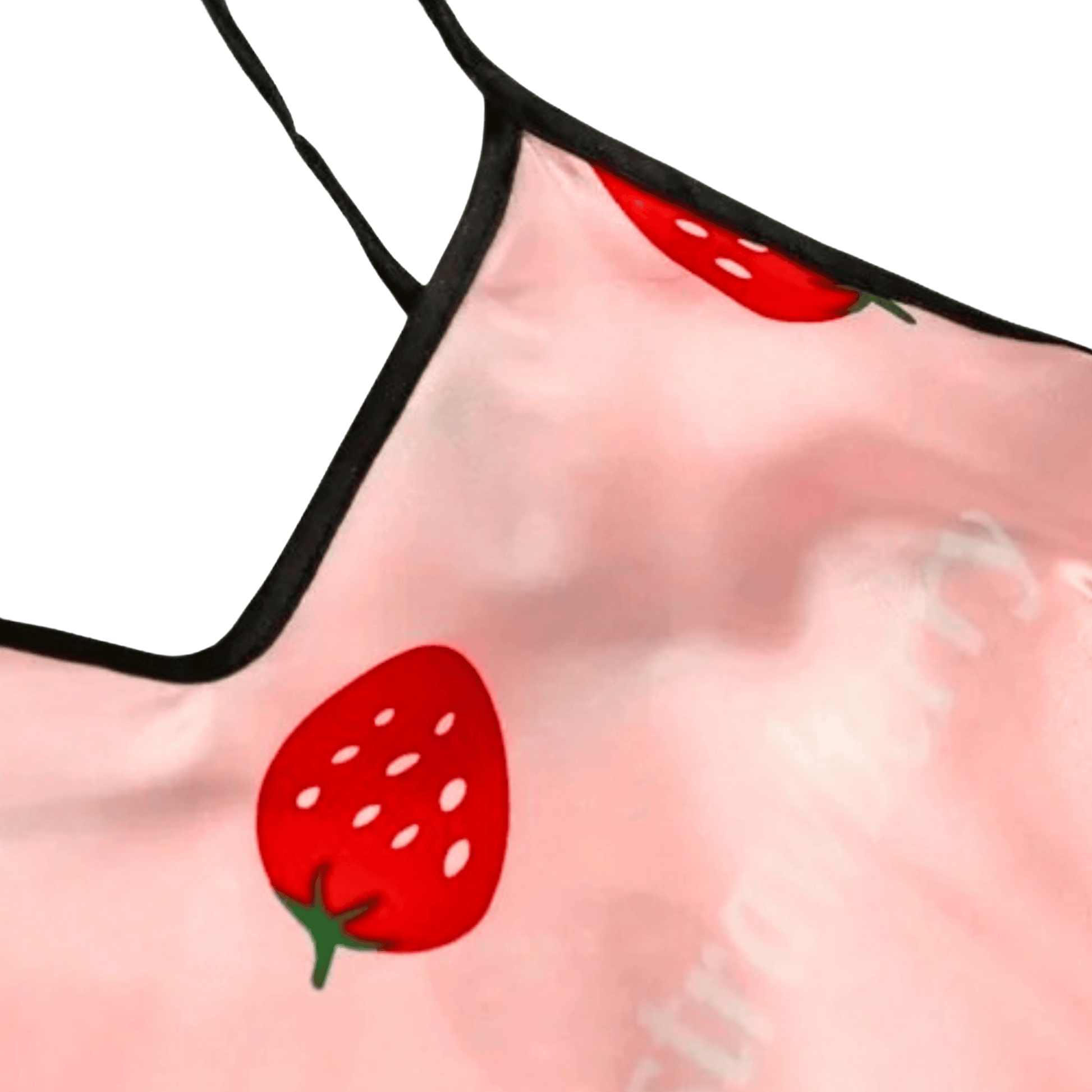 Pink fabric with red strawberry pattern on a green background