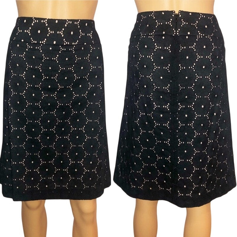 Black skirt with white floral pattern on a mannequin against a white background