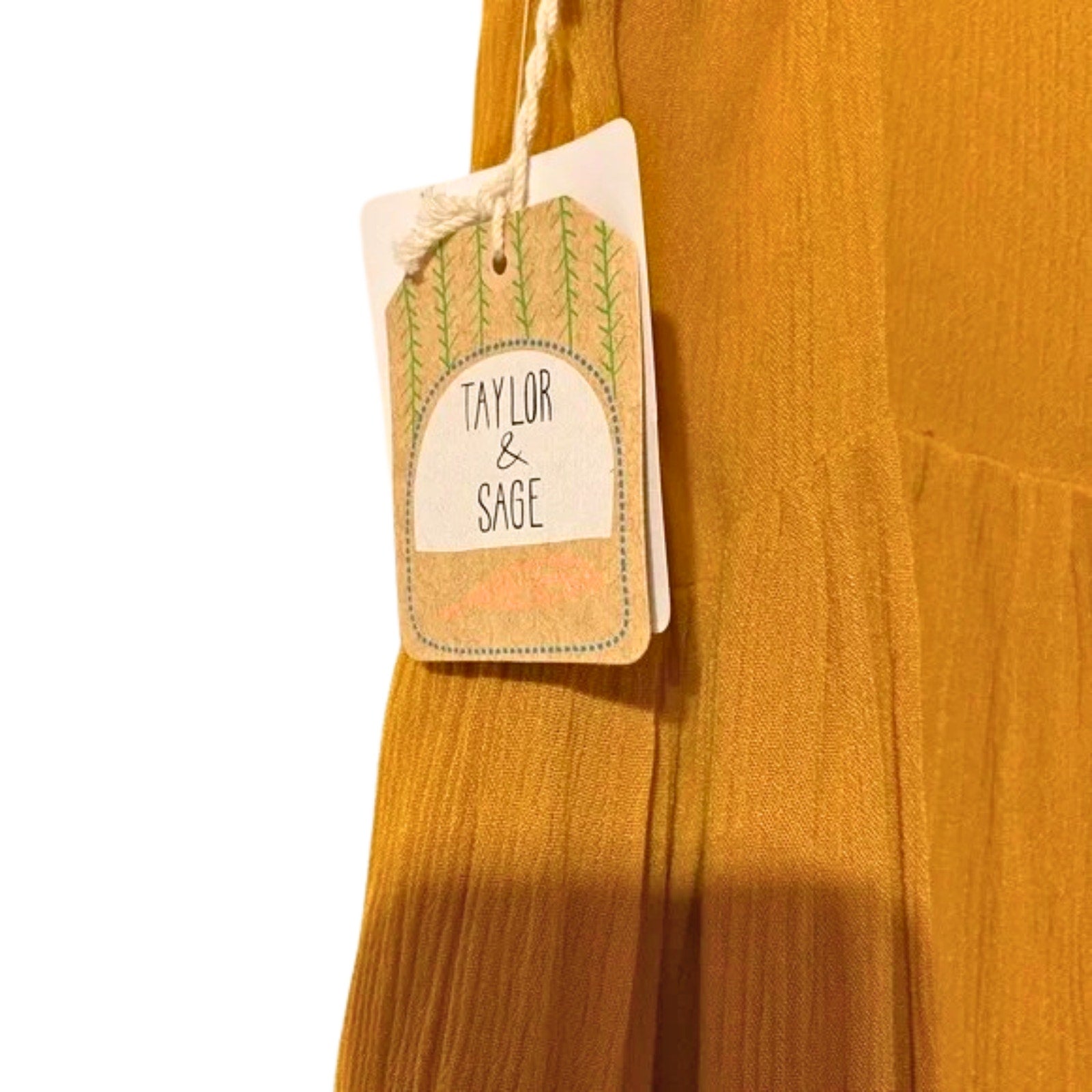 Mustard yellow fabric with a 'Taylor & Sage' tag on a white background