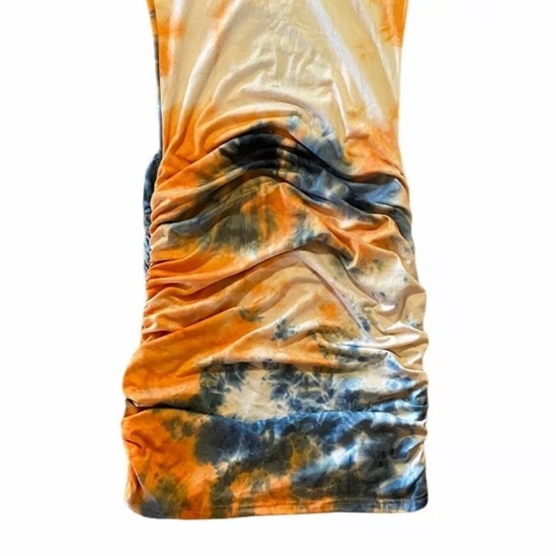 Tie-dye patterned fabric in orange, blue, and black on a white background