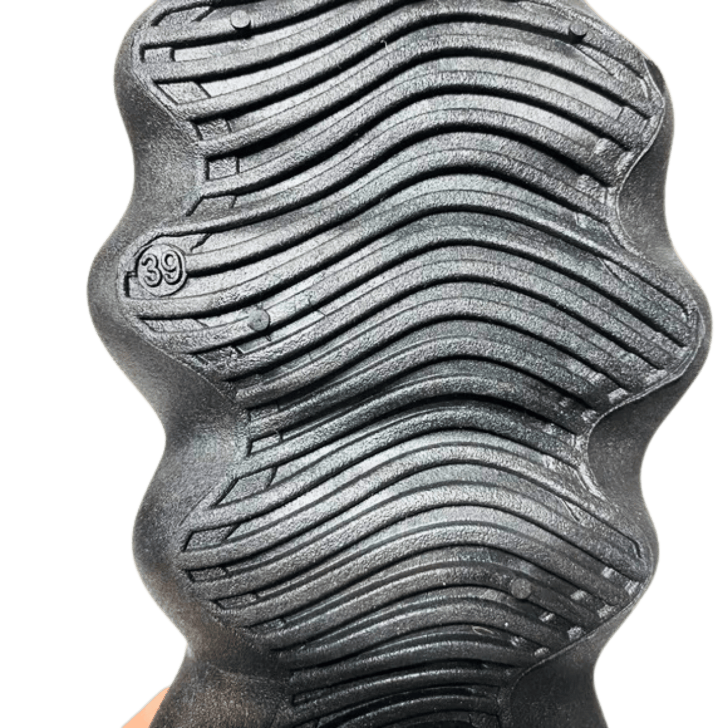 Close-up of a textured metal object with wavy pattern and '39' marking on a green background