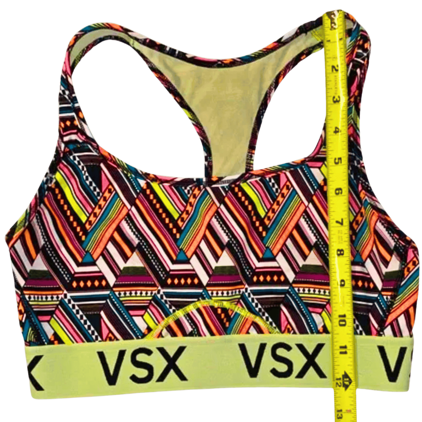 Colorful patterned sports bra with 'VSX' branding and a measuring tape on a transparent background