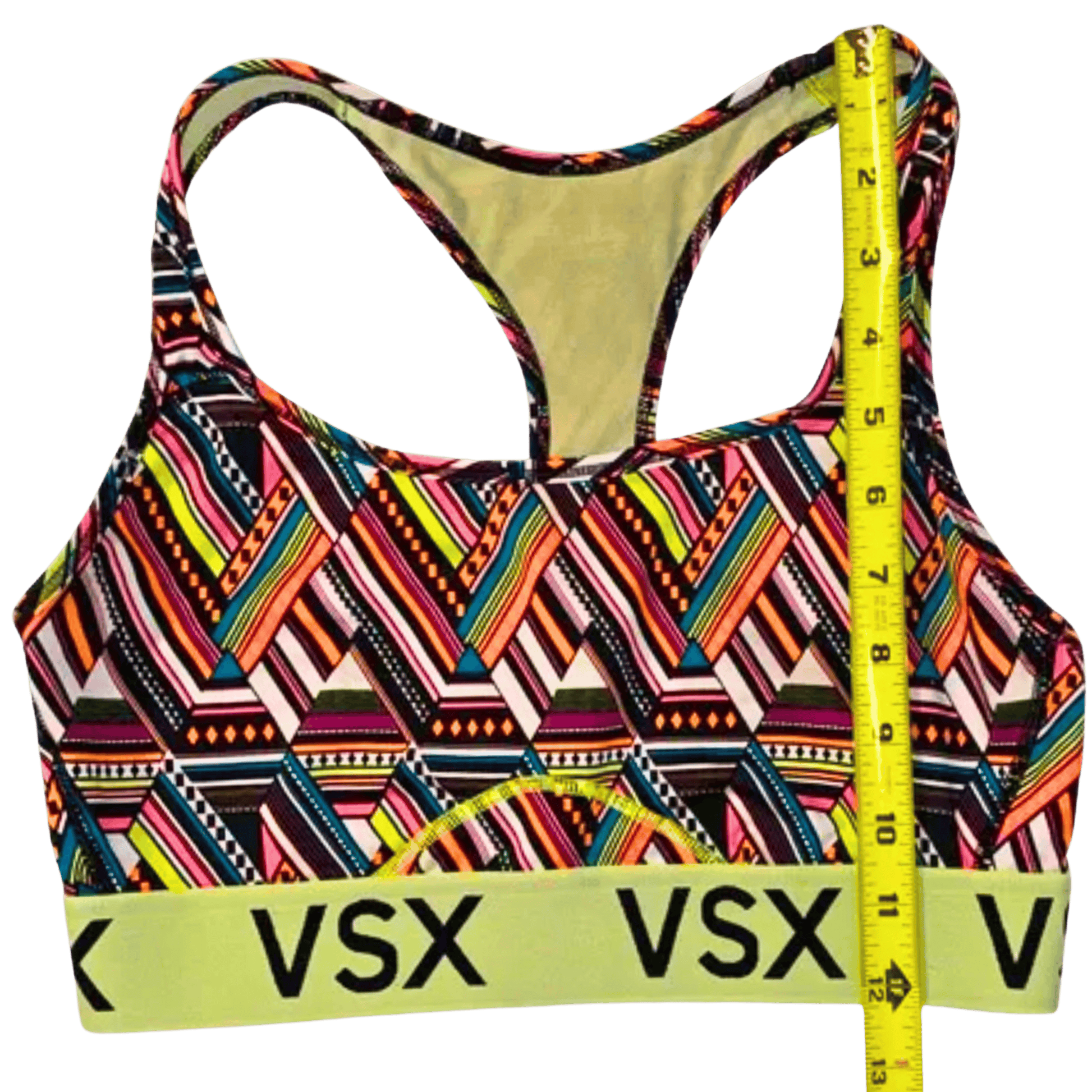 Colorful patterned sports bra with 'VSX' branding and a measuring tape on a transparent background