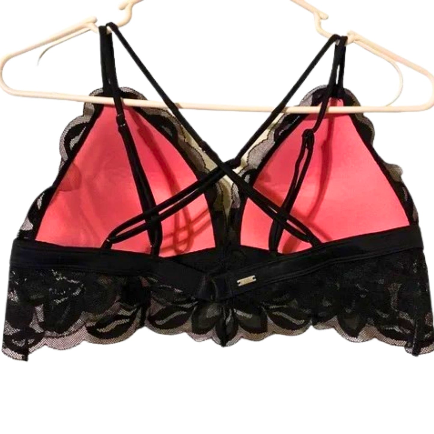Black lace-trimmed bra with pink interior on a hanger against a white background