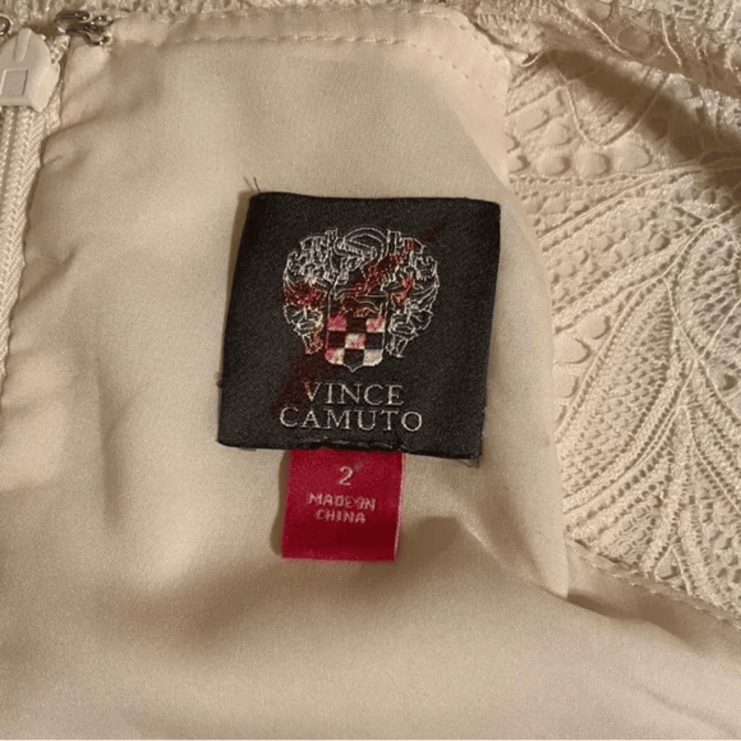 Vince Camuto label on a beige garment with a textured background