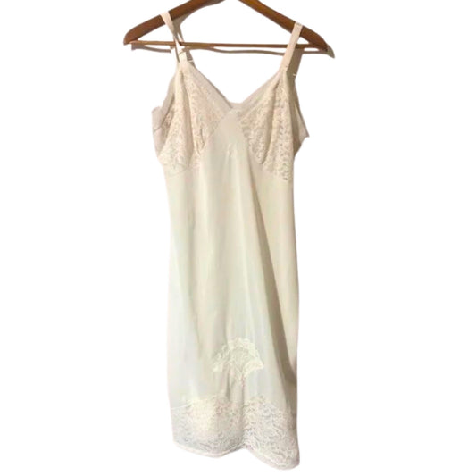 Cream-colored lace camisole on a wooden hanger against a white background