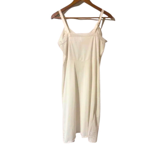 Beige slip dress on a wooden hanger against a white background
