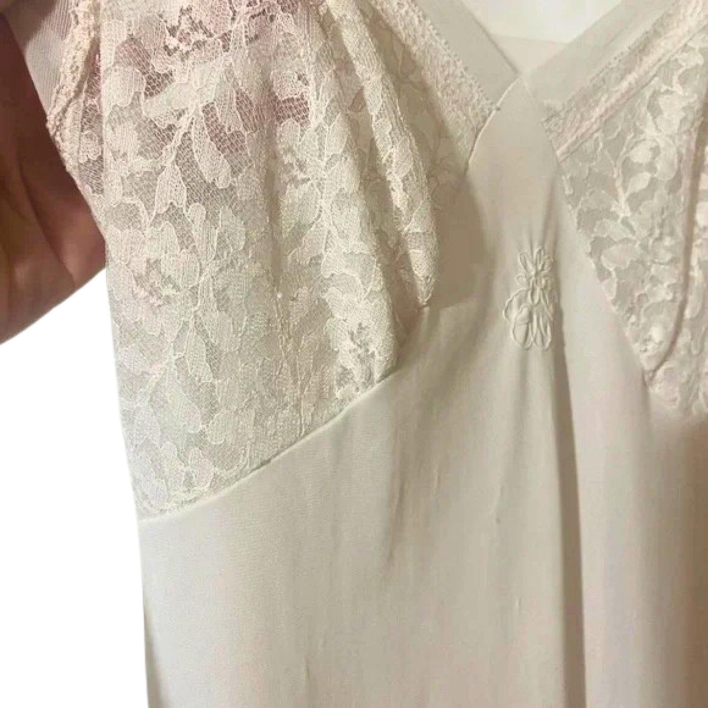 Close-up of a white lace garment with a floral design.