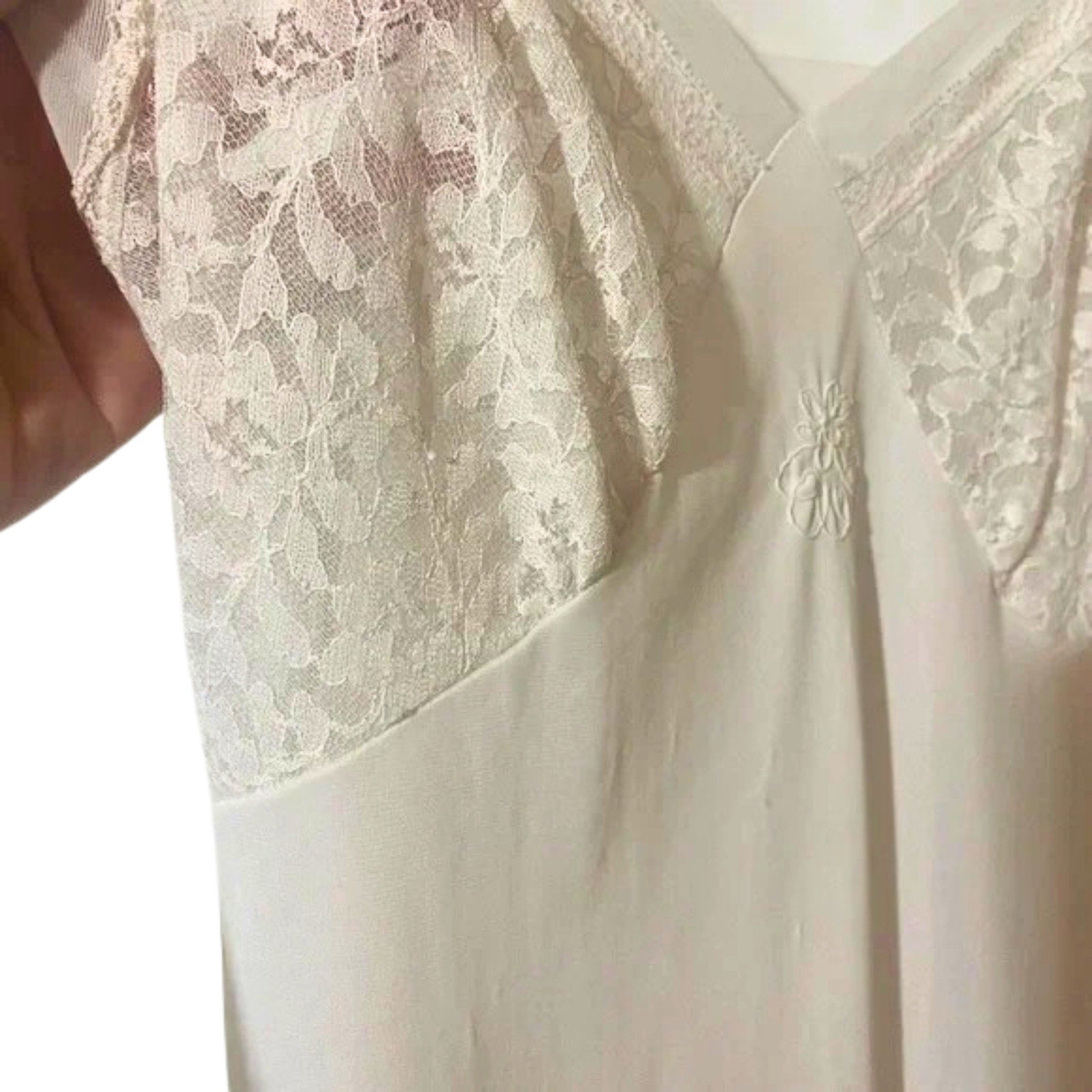 Close-up of a white lace garment with a floral design.