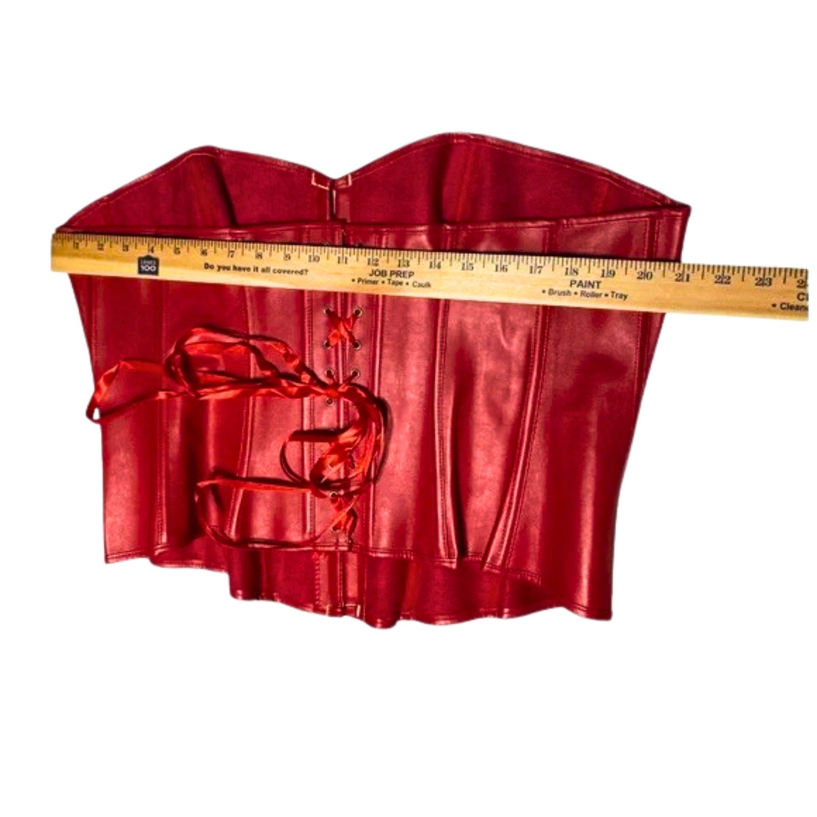 Red satin top with a measuring tape for size reference on a white background