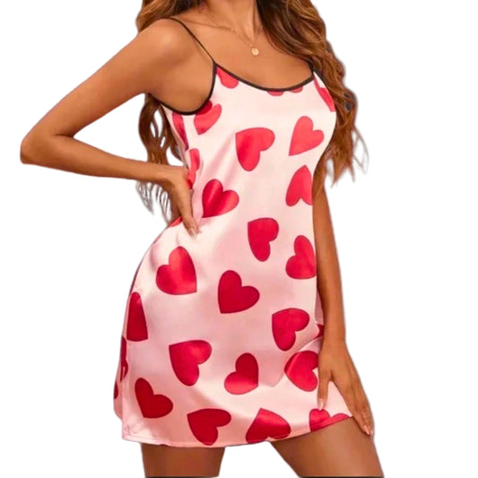Woman wearing a pink nightgown with red heart patterns on a white background