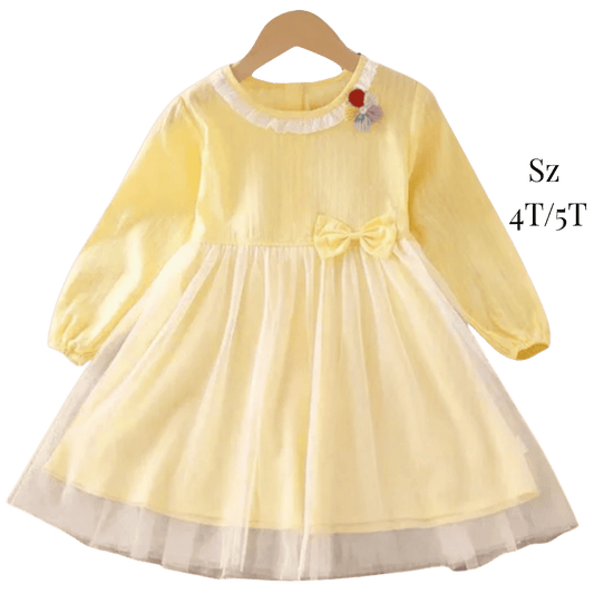 Yellow dress with a bow on a hanger against a green background