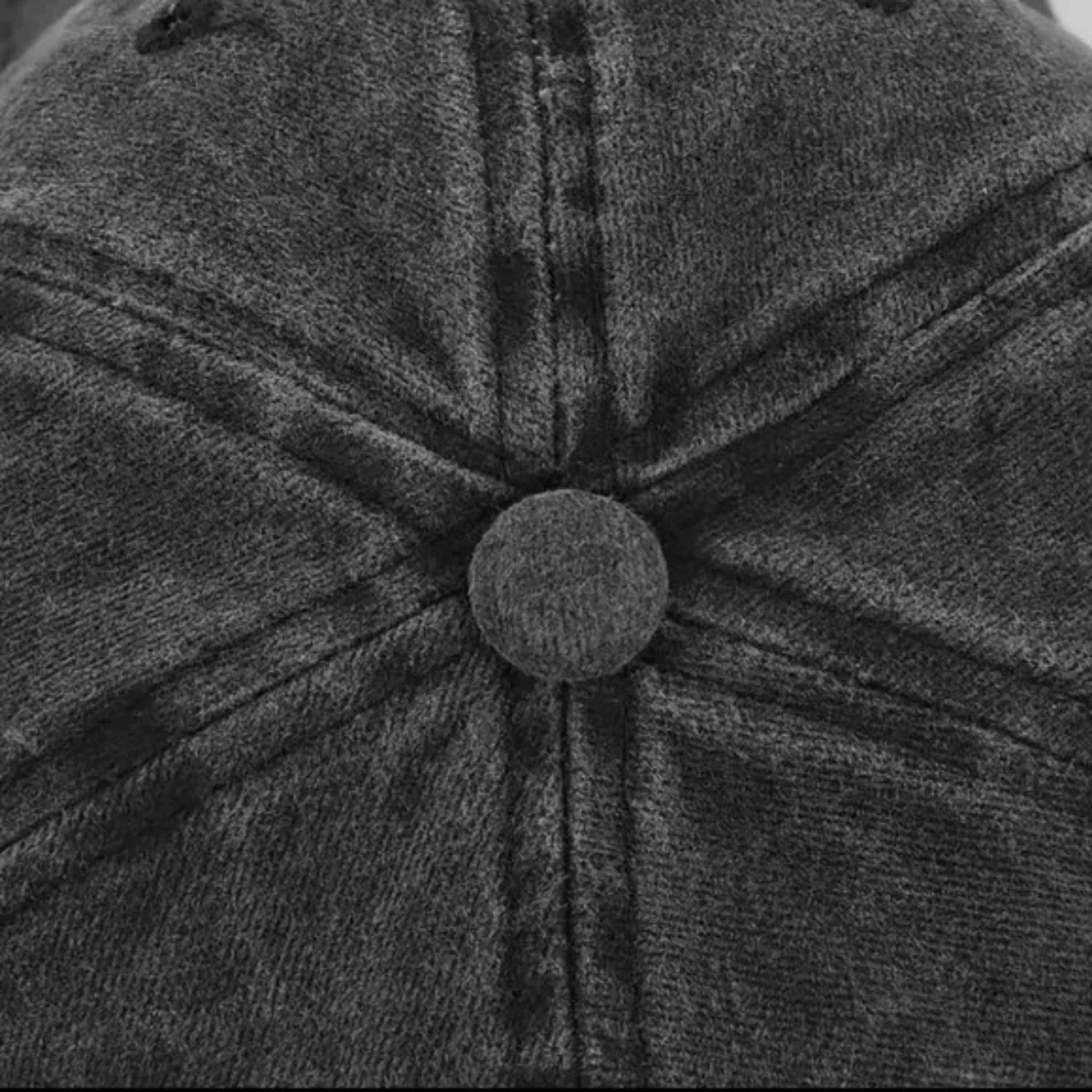 Close-up of a textured gray cap with a button detail