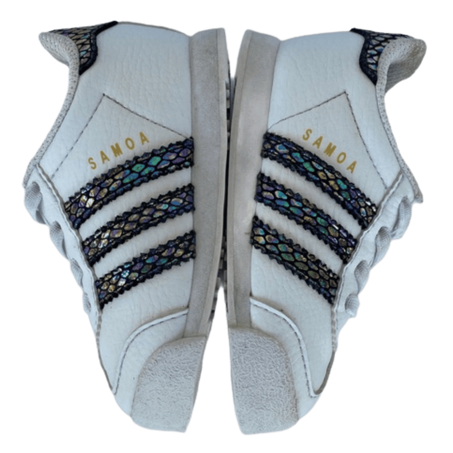 White sports shoes with black and gold accents and 'Samoa' text on a transparent background