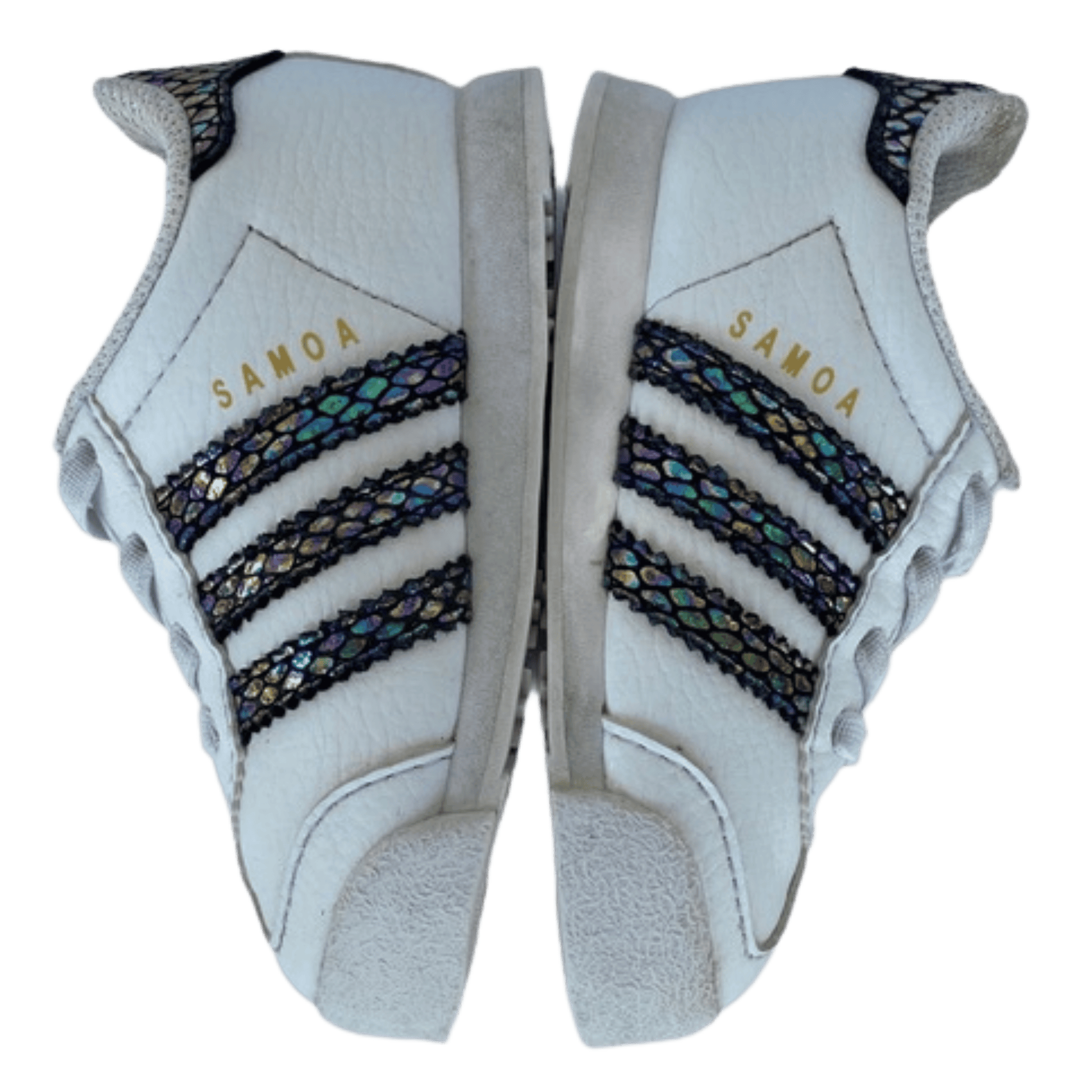 White sports shoes with black and gold accents and 'Samoa' text on a transparent background