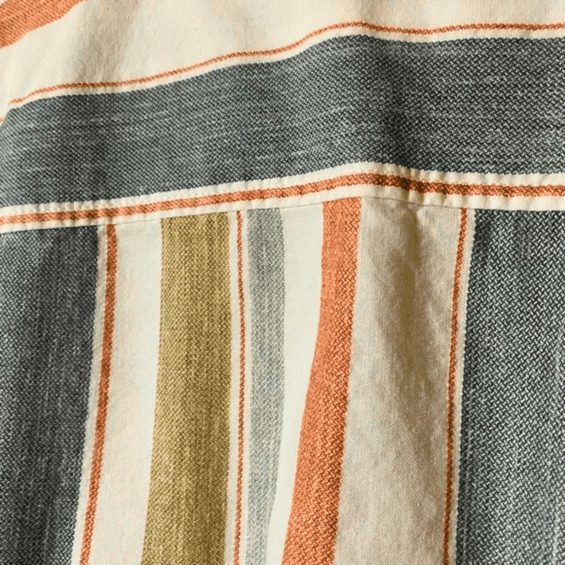 Close-up of a fabric with striped pattern in blue, orange, and green.