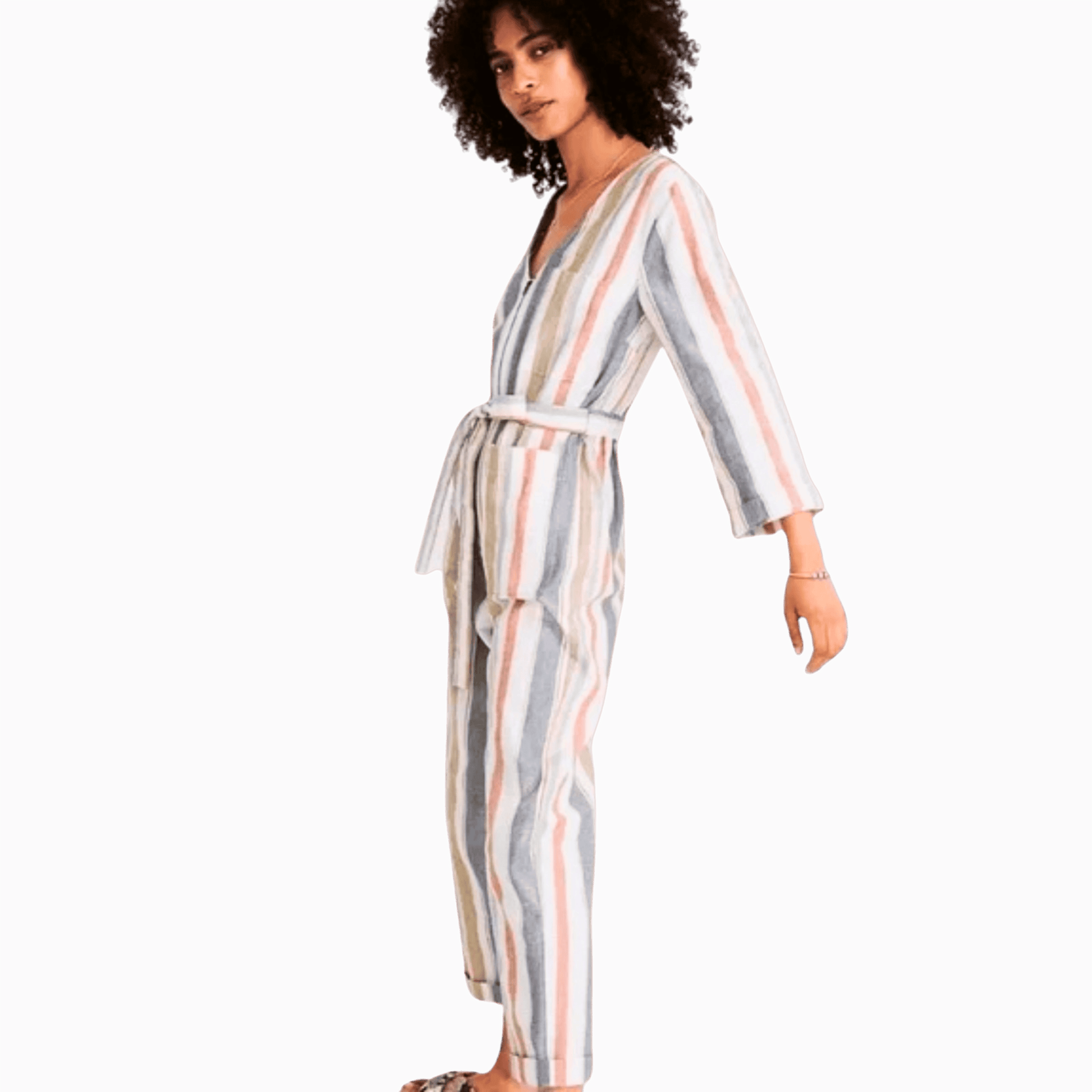 Woman wearing a striped jumpsuit on a purple background