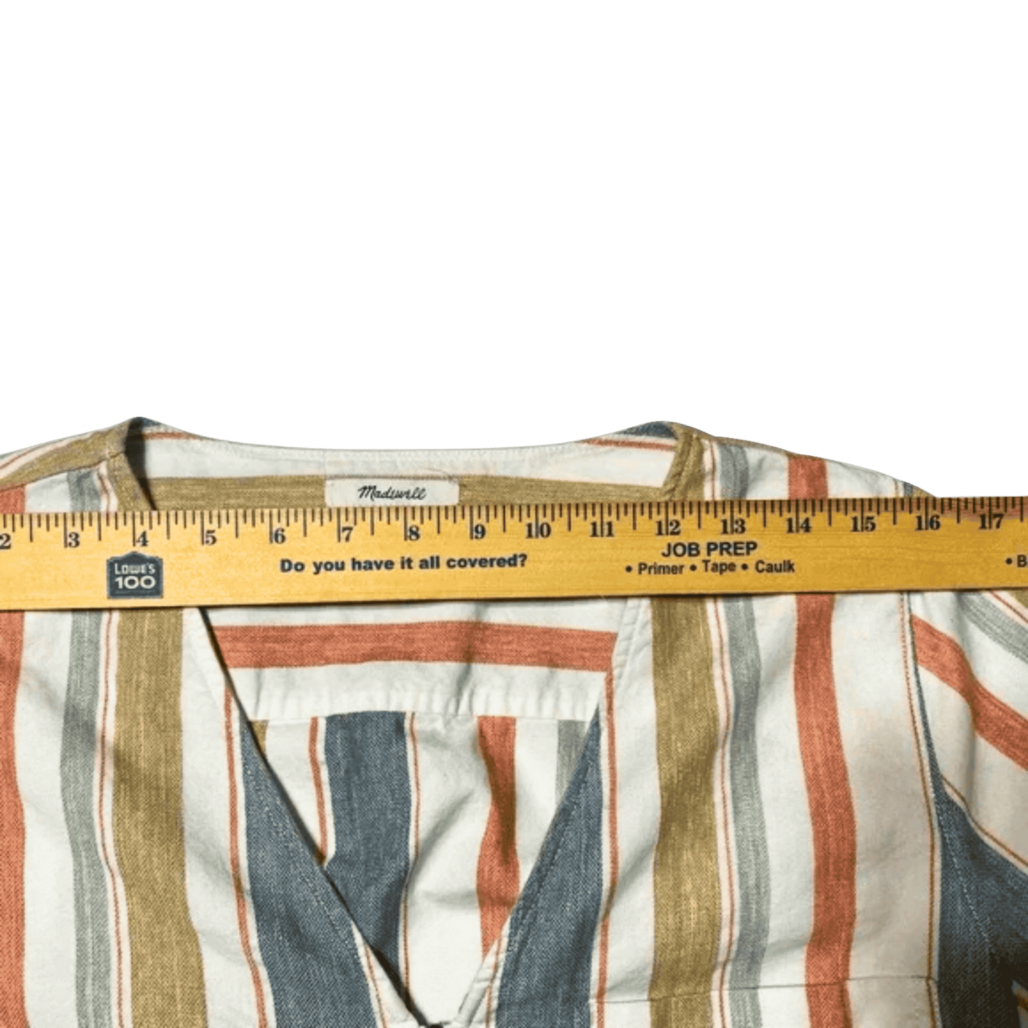 Striped shirt with a ruler on top against a green background