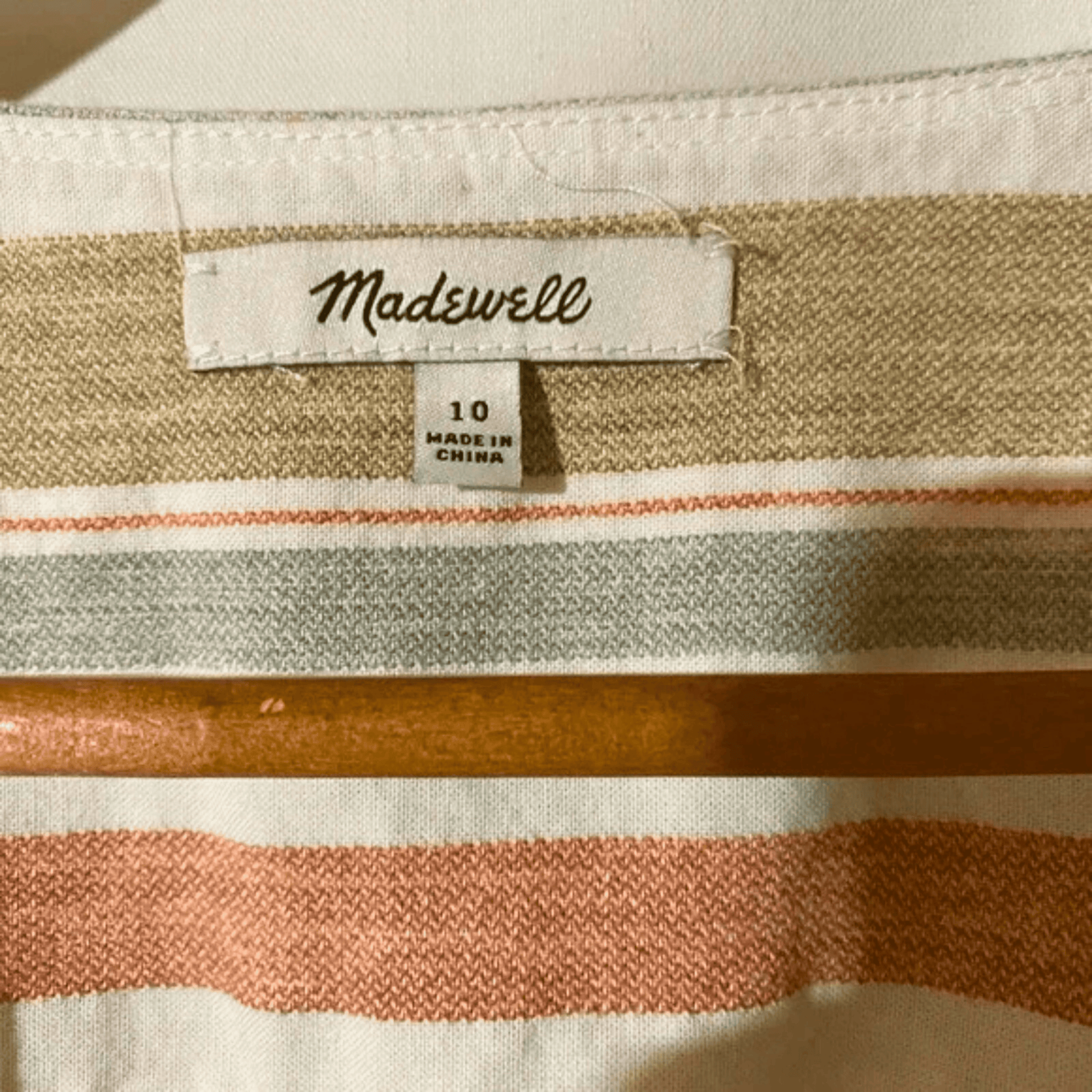 Close-up of a striped fabric with a Madewell label on a beige background