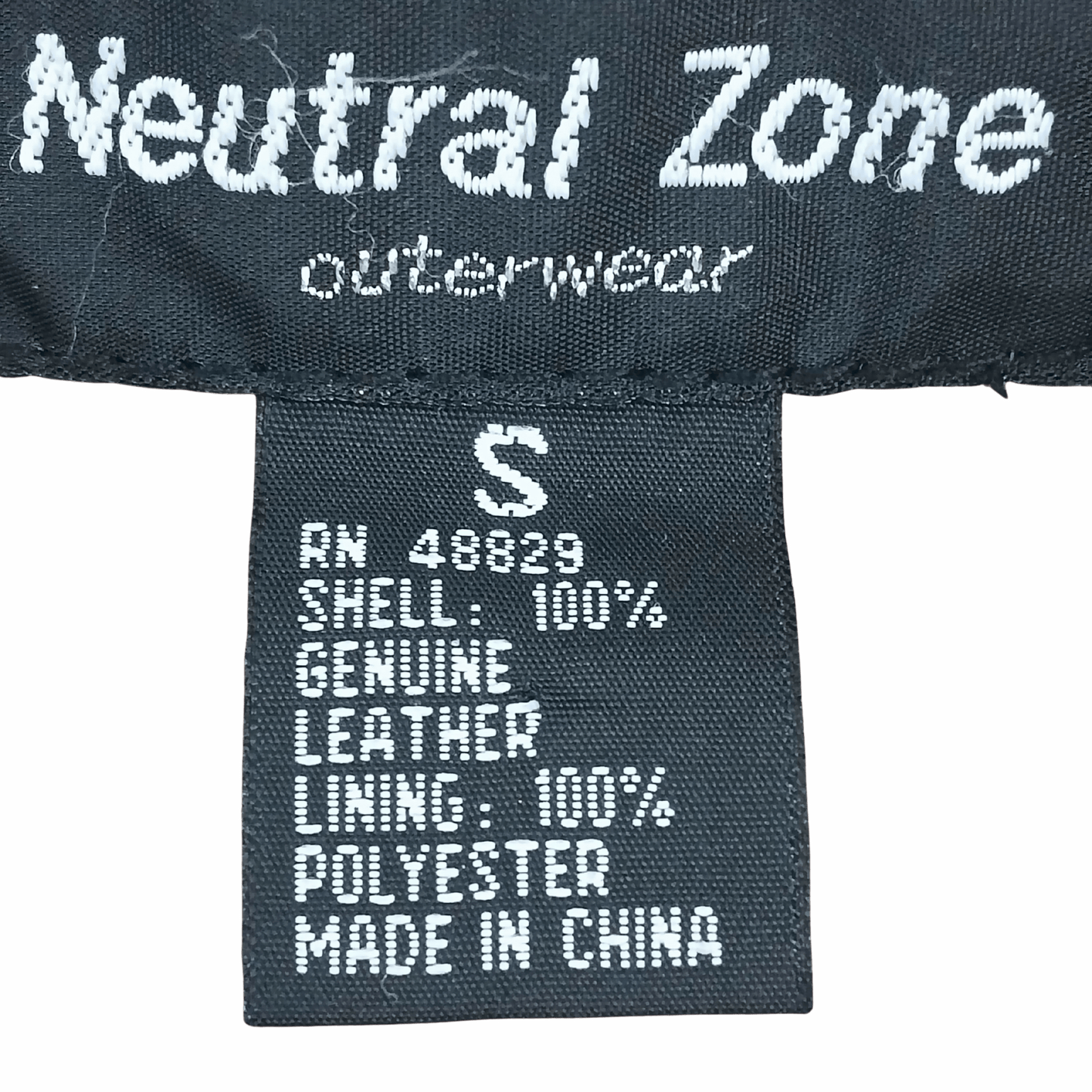 Label on a piece of clothing with 'Neutral Zone Outerwear' branding and material information.