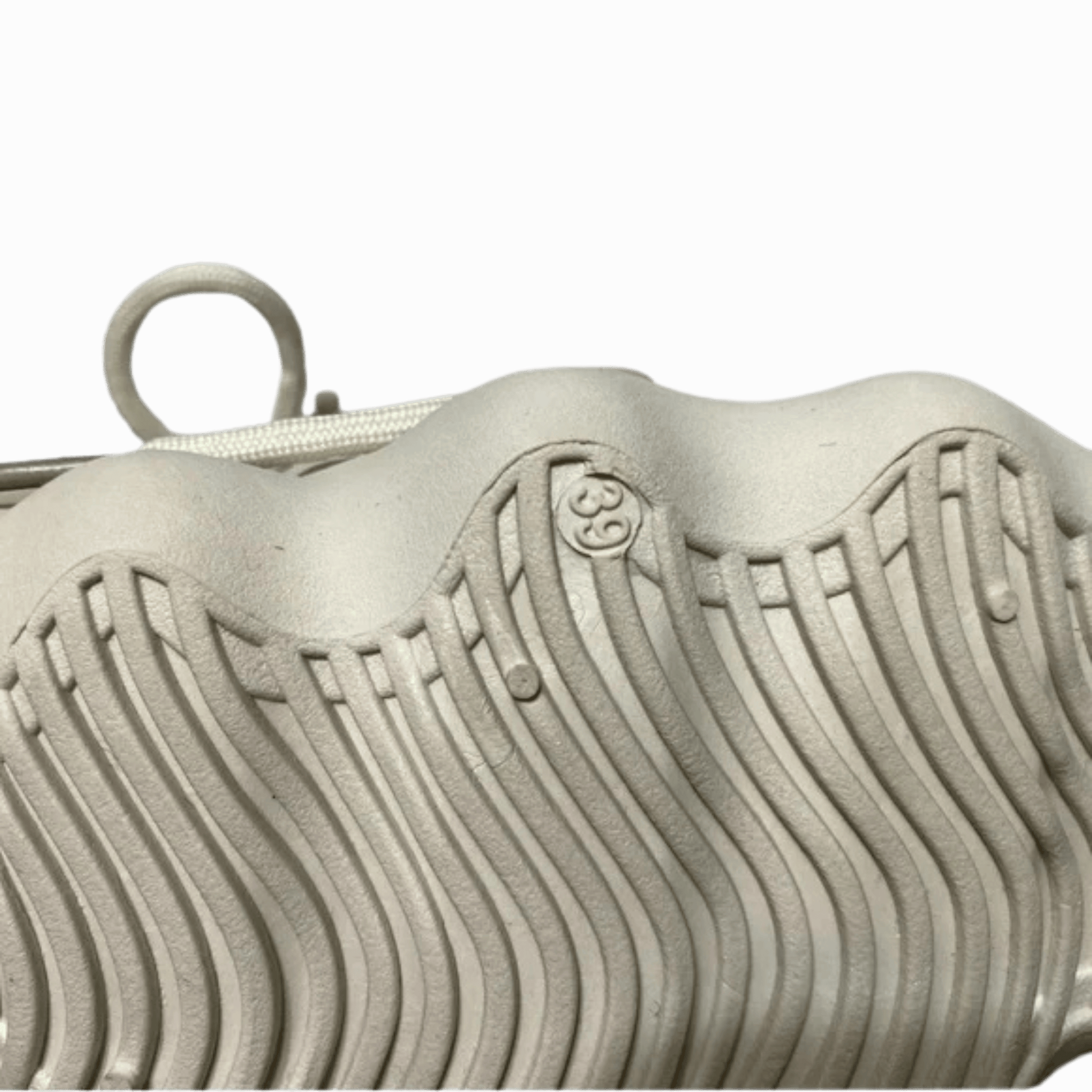 Close-up of a textured metallic object with a logo on a dark background