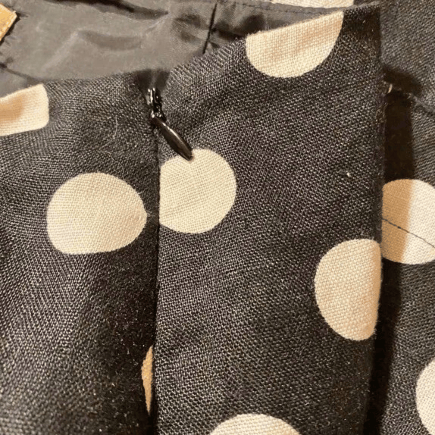 Close-up of a fabric with beige polka dots on a dark background