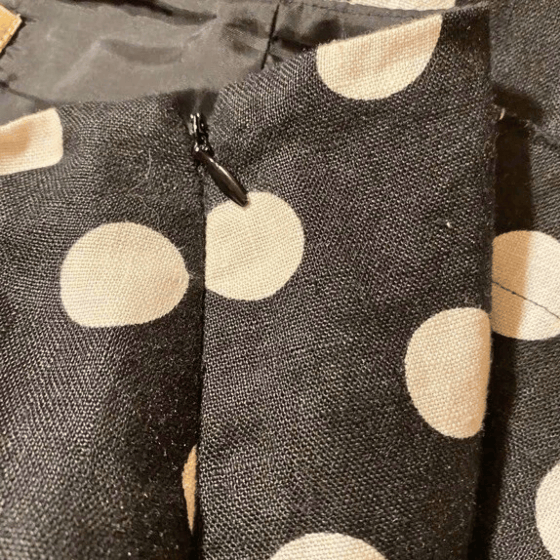 Close-up of a fabric with beige polka dots on a dark background