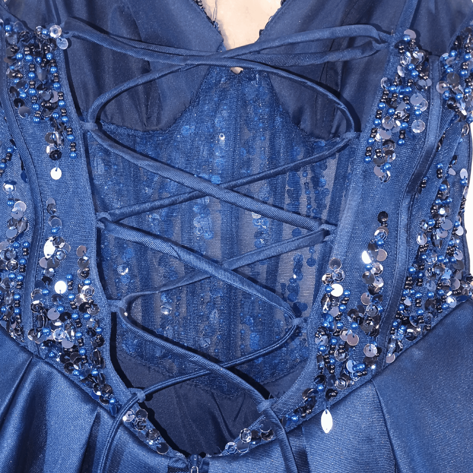 Close-up of a blue dress with intricate lace and bead detailing.