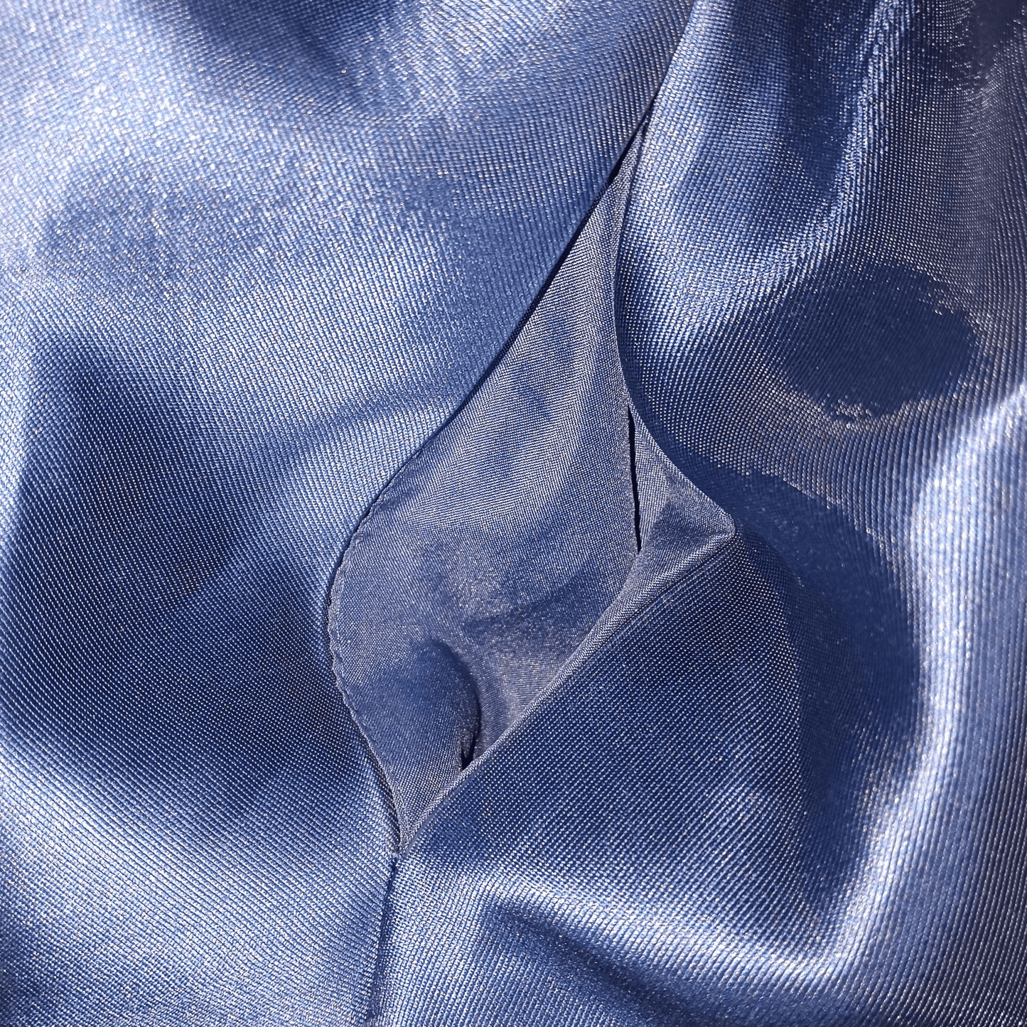 Close-up of blue satin fabric with folds