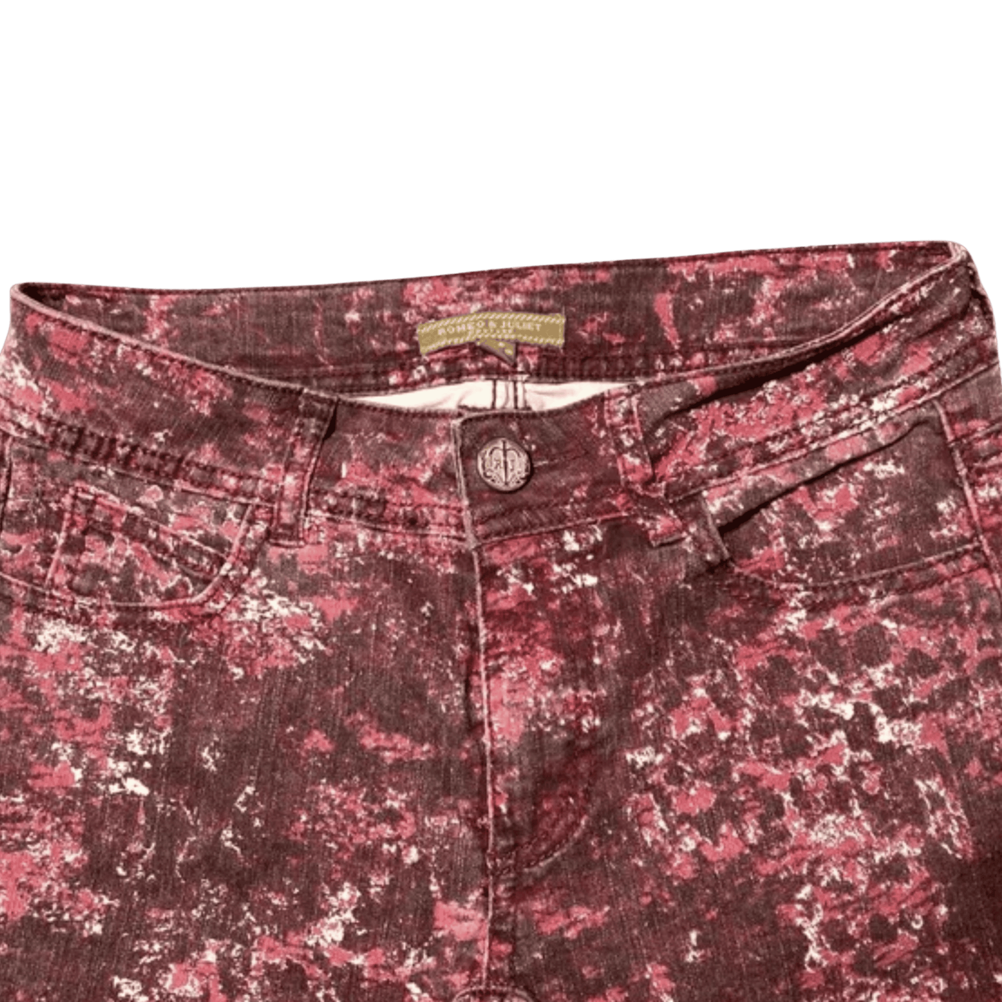 Close-up of a pair of maroon camouflage pants with a brand label on a green background.