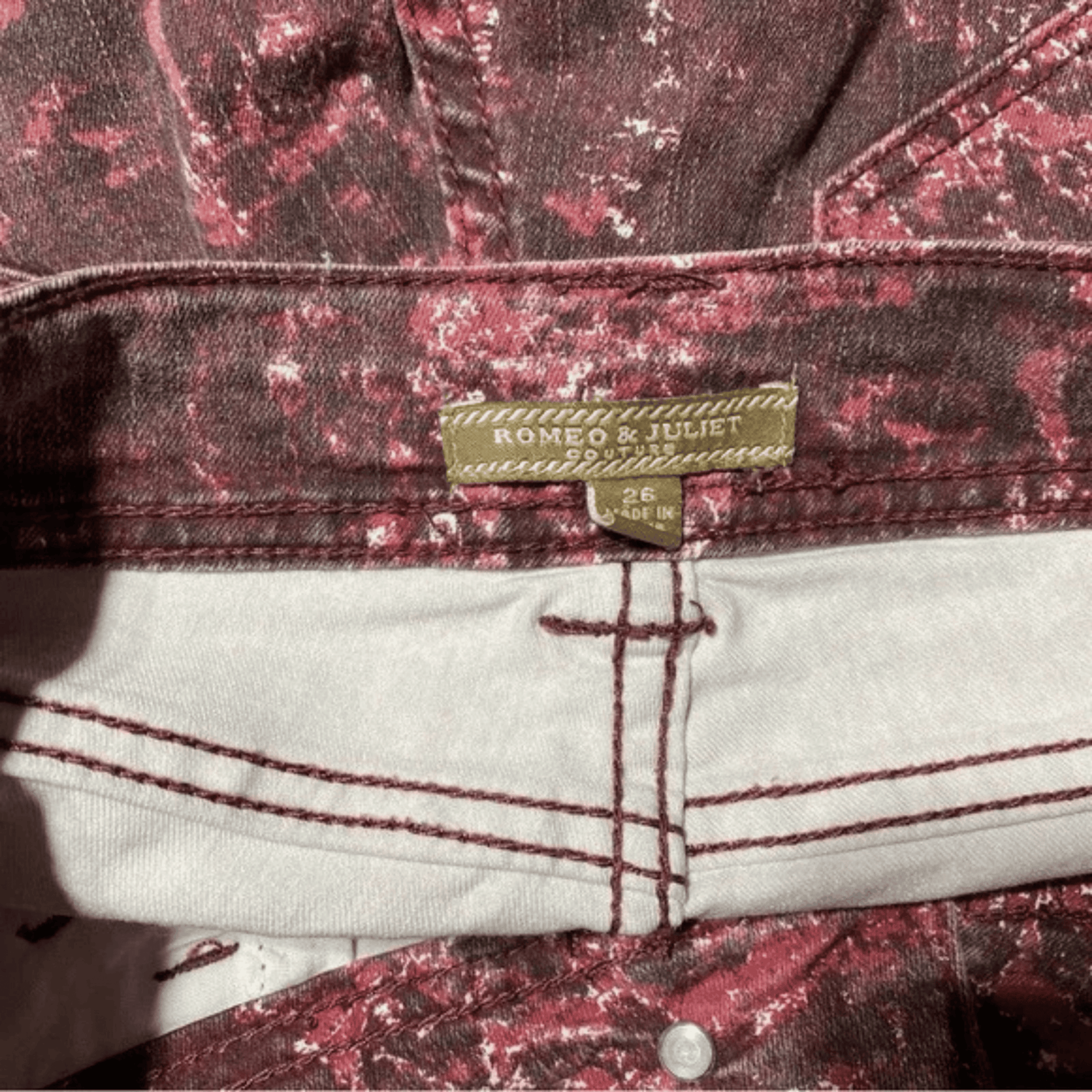 Close-up of a denim jacket with a brand label on a floral patterned background