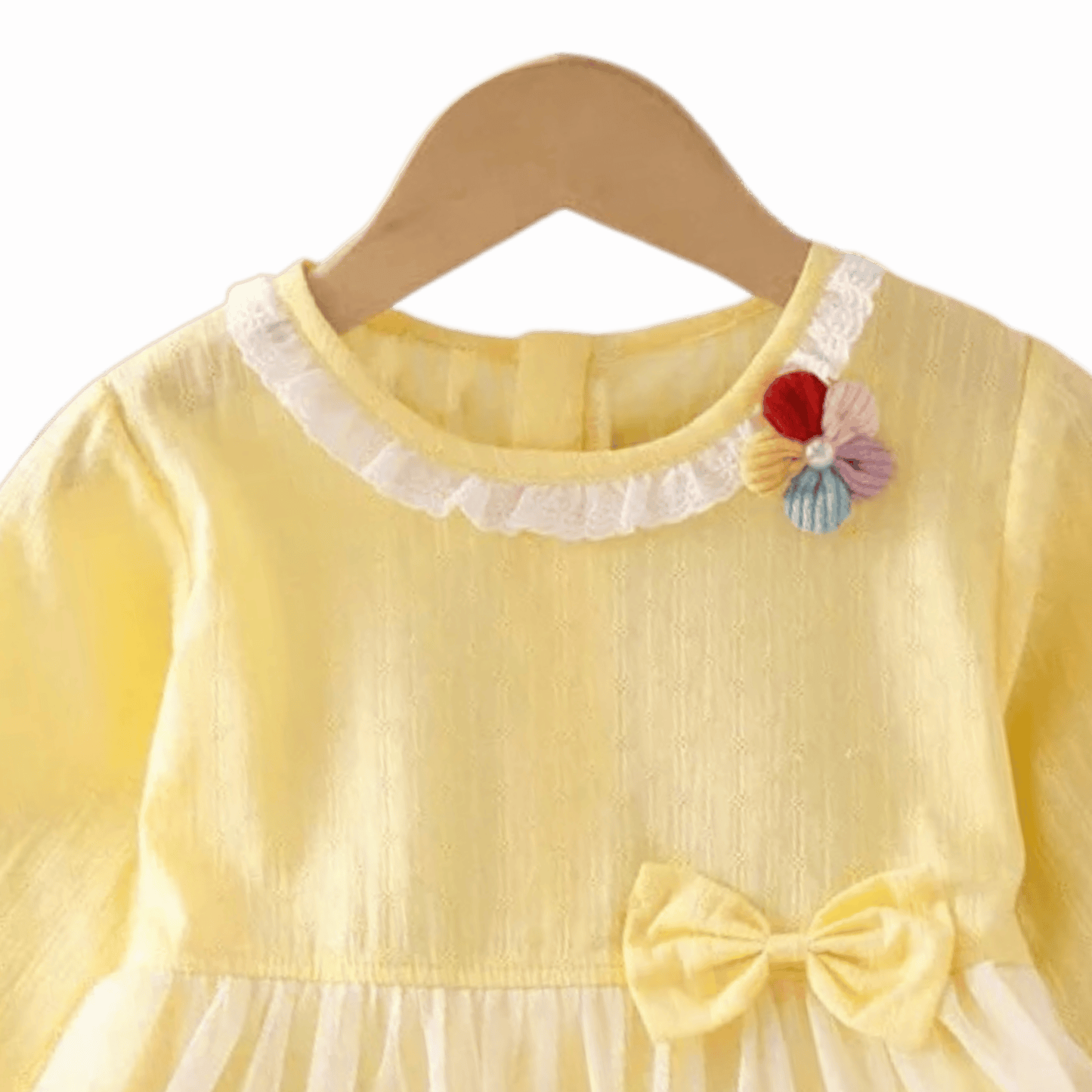 Yellow dress with floral details and a bow on a beige background