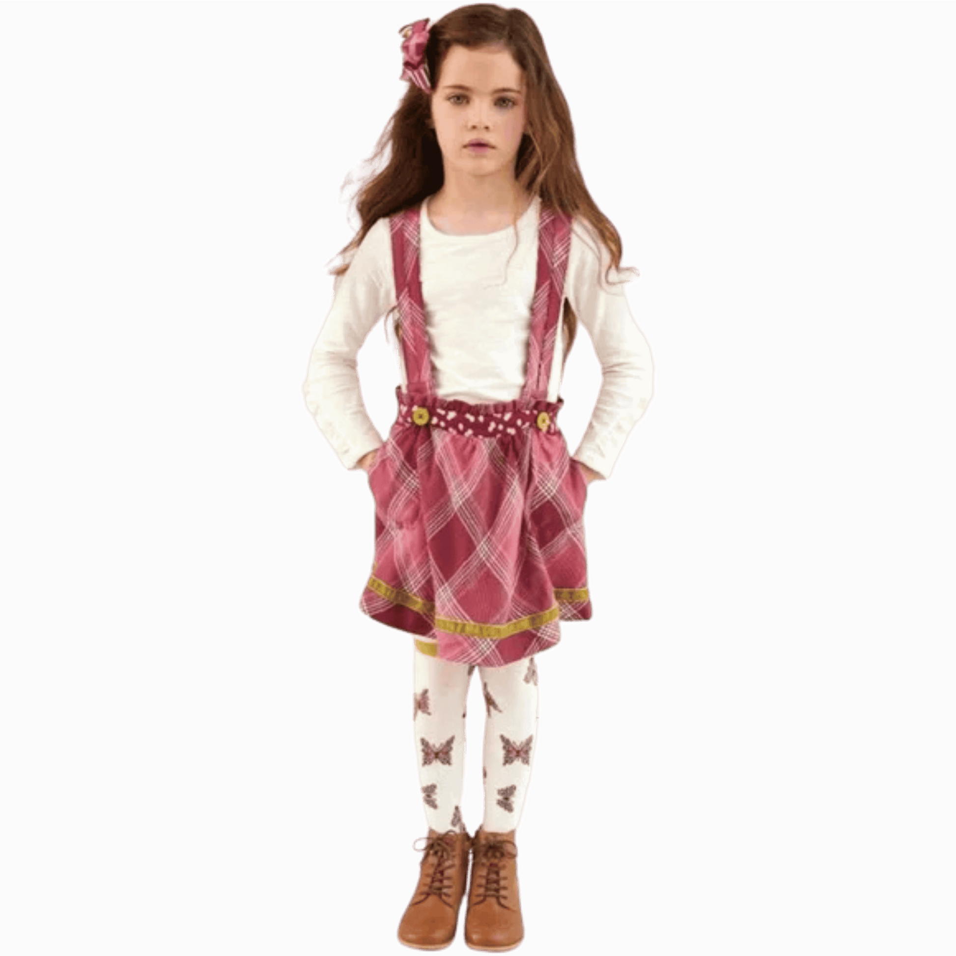 Young girl wearing a pink plaid dress with a white shirt and brown boots on a maroon background