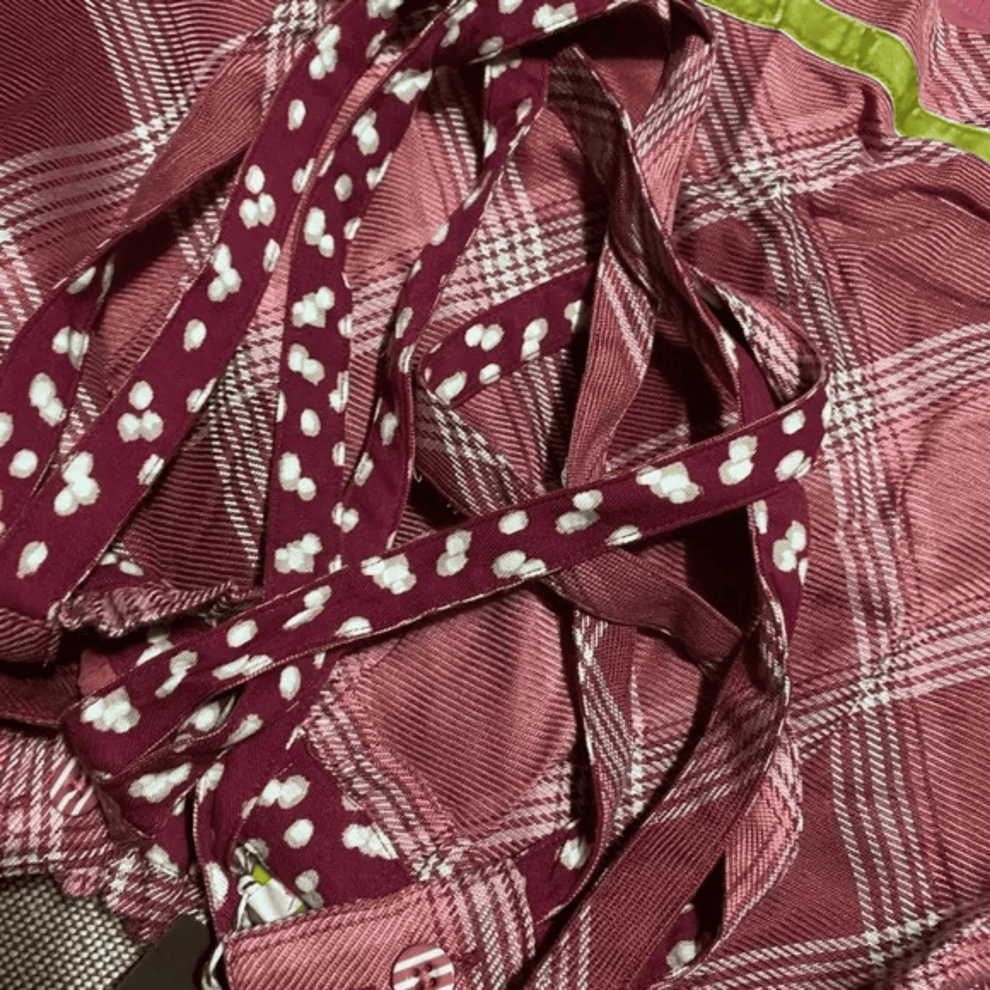 Close-up of maroon ribbons with white patterns on a textured surface