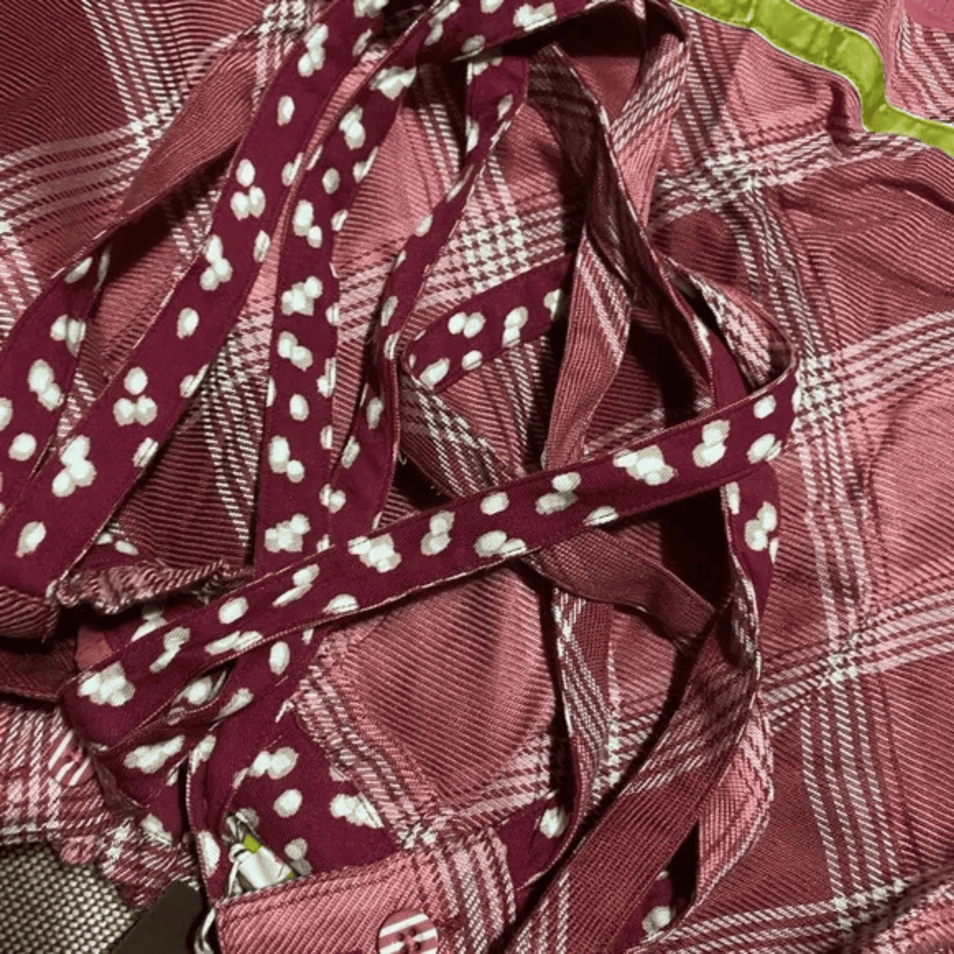 Close-up of maroon ribbons with white patterns on a textured surface